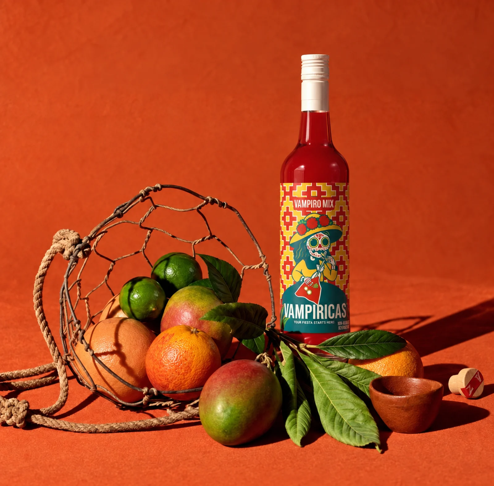 Vampiricas bottle with a net of citrus and mango on an orange backdrop